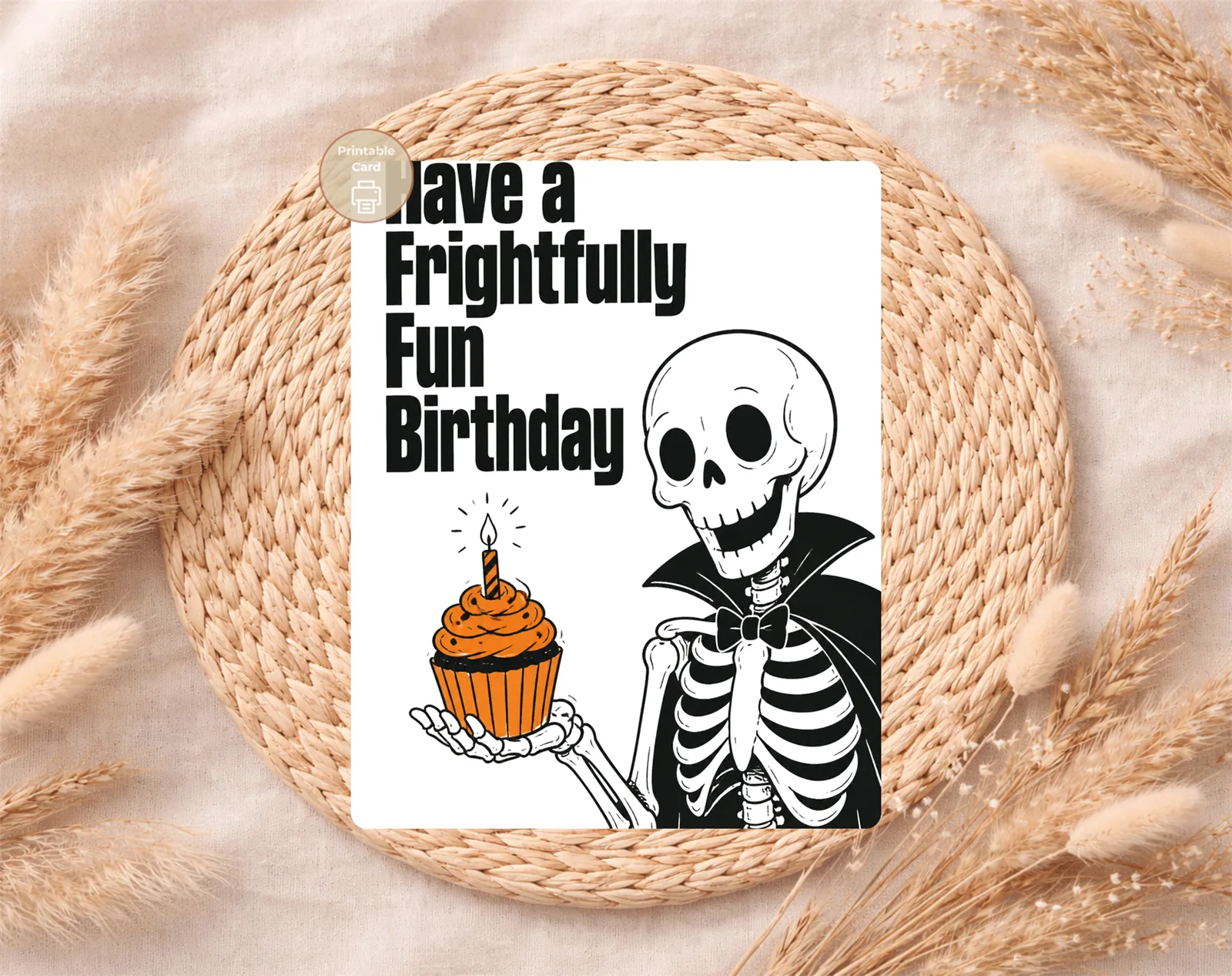 Close view of the card artwork and printed message: Make their birthday deliciously spooky with a frightfully fun skeleton serving an orange cupcake in bold gothic style.