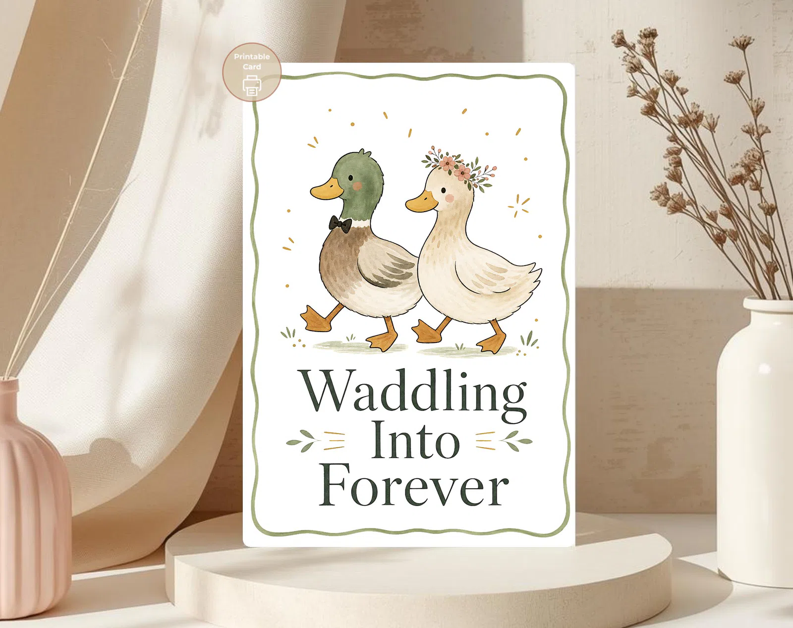 Styled product mockup: A charming printable wedding card with a watercolor duck couple dressed for the aisle, surrounded by a soft green border and warm celebratory accents.