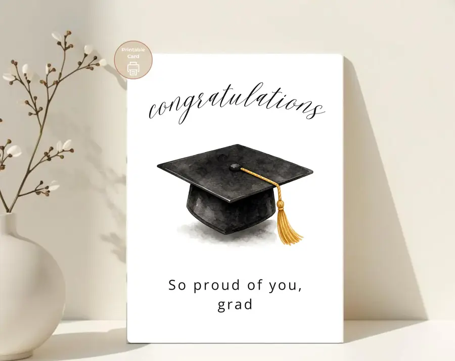 Styled product mockup: A polished printable graduation card for celebrating a graduate with a classic black mortarboard and gold tassel.
