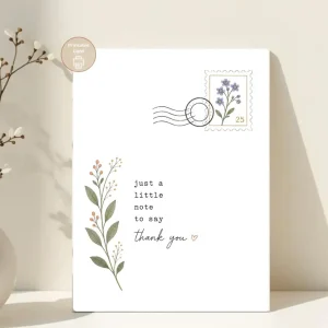 Styled product mockup: A printable thank you card with a black botanical design, delicate leafy stem, floral postage stamp, and soft handwritten lettering.