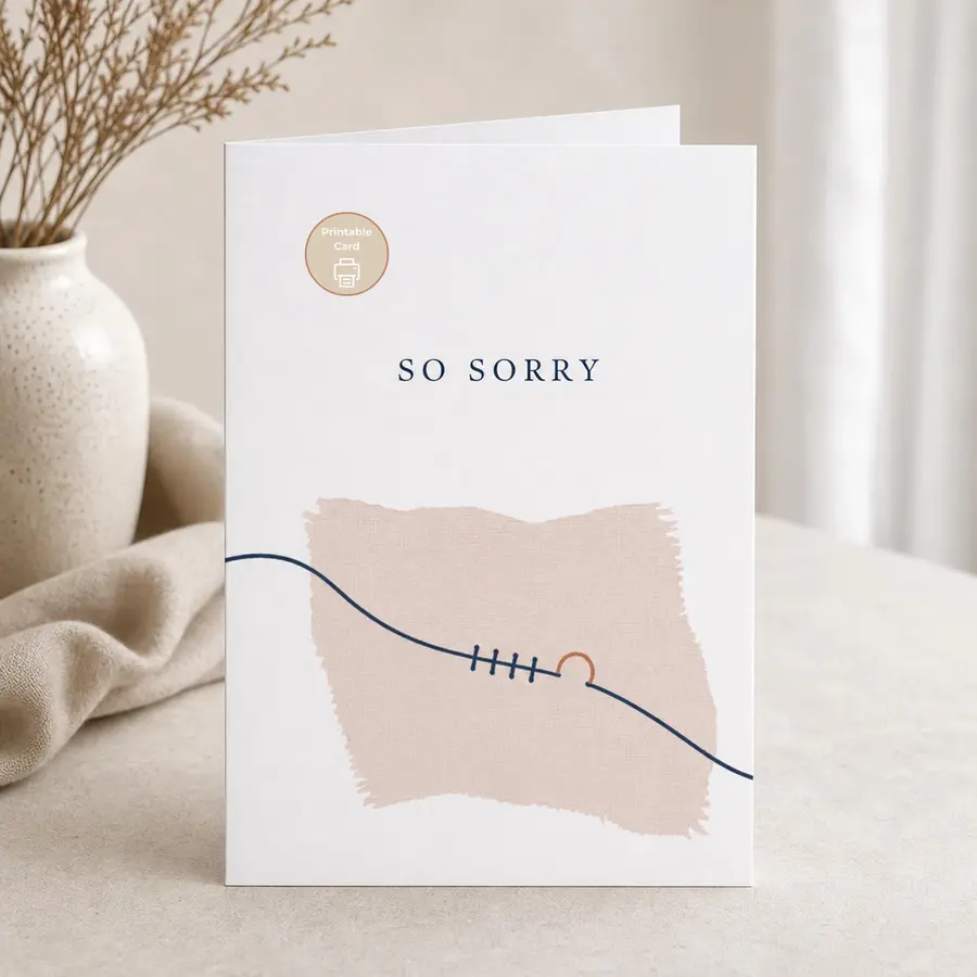Styled product mockup: A quiet printable sympathy card with spaced navy lettering and a soft stitched fabric detail.